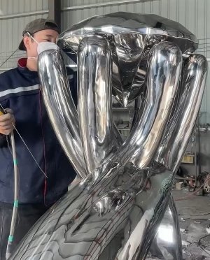 Custom stainless steel sculpture polishing process by XinYe Metal, showcasing mirror finish on metal artwork