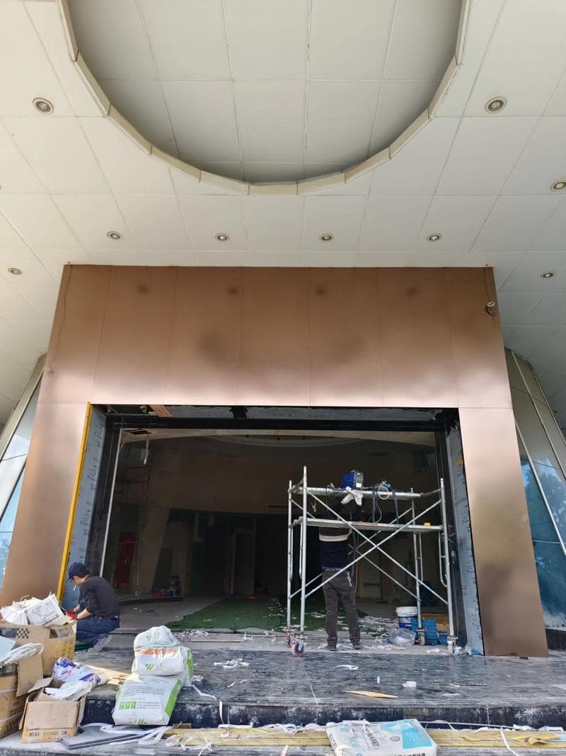 Shopping mall entrance door decorated with copper-colored stainless steel panels