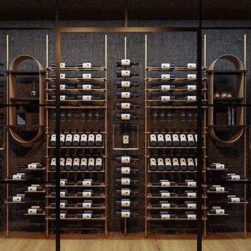 Custom gold-finished stainless steel wine cabinet with glass-front doors, adjustable shelving, and integrated LED lighting, installed in an upscale bar interior.